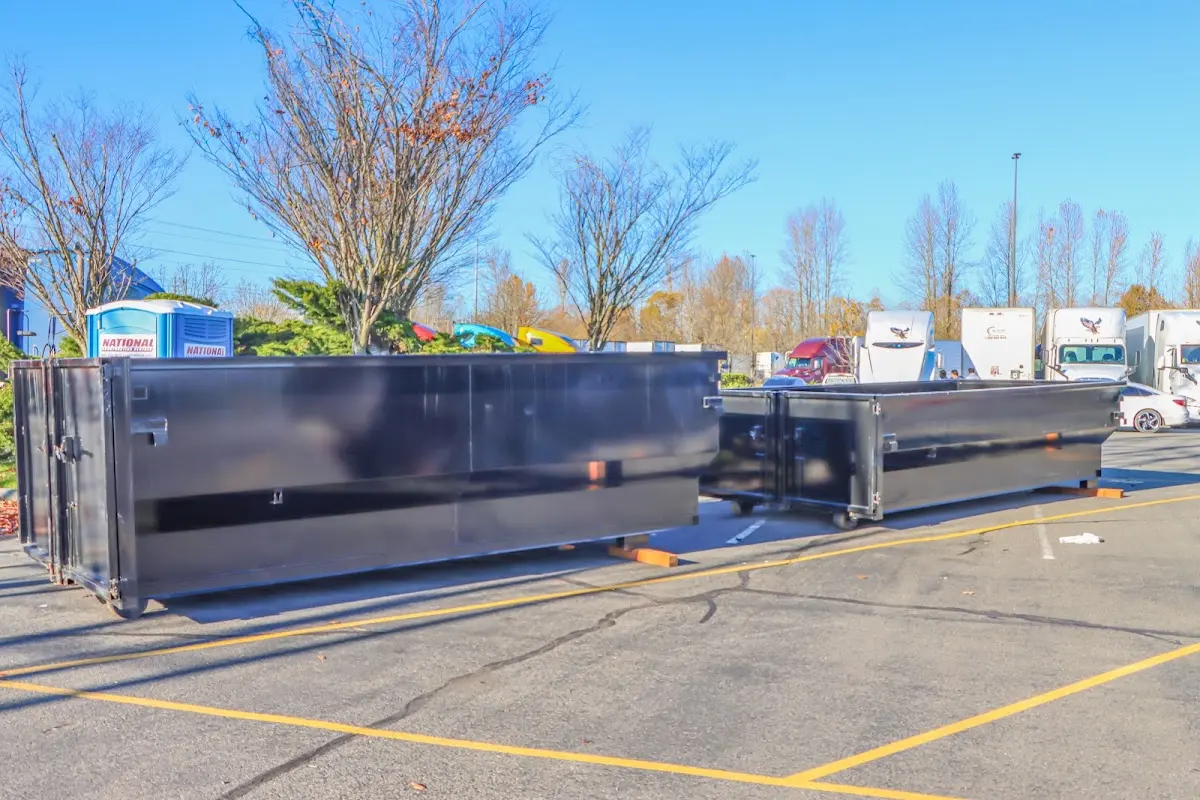 Professional dumpster rental service with roll-off container on residential driveway in Mount Hope